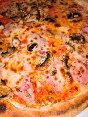 Ağzını sulandıran pizzayı fırından yeni çıkmış jambon ve mantarla kapat. Erimiş peynirini ve çıtır çıtır kabuğunu göster.