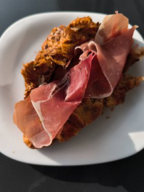 Prosciutto dilimleri taze pişmiş kruvasana konur, lezzetli ve cezbedici bir aperatif ya da yemek oluşturur.