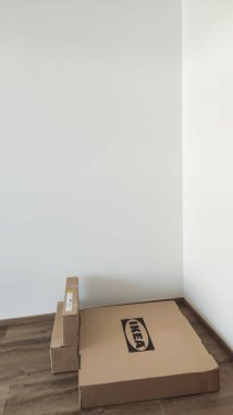 Prag, Çek Cumhuriyeti - 15 Temmuz 2024: Açılmamış iki ikea karton kutu boş bir odada zemin döşemesi gibi beyaz bir duvara yaslanıyor