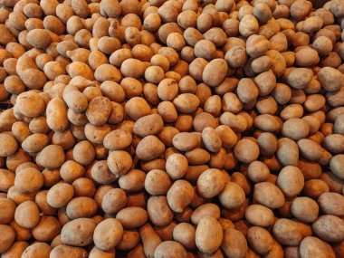 Birçok patates, bu ortak gıda öğesinin bir markette veya bakkalda bolluk ve ulaşılabilirliğini öne süren dokulu bir arka plan oluşturmaktadır.