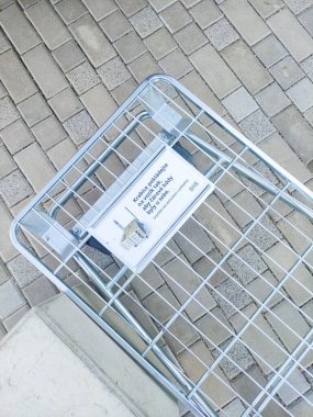 Prag, Çek Cumhuriyeti - 17 Temmuz 2024: Prag, Czechia 'da bir kaldırım taşı caddesinde duran metal ikea alışveriş arabası, Czechia' da müşterilerden barkodların görünür olması için kutuları yerleştirmelerini isteyen bir tabela ile