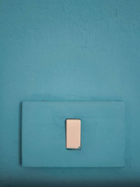 Sadelik ve işlevsellik üzerine odaklanmış minimalist bir iç tasarım konseptini temsil eden boyanmış bir duvardaki beyaz ışık düğmesini kapat