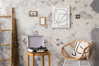 Dizayn sandalyesi, yastığı, halısı, vinil kayıt cihazı, tabloları ve kişisel aksesuarları olan modern bir daire. Minimalist ev dekorasyonu. Şablon. Çamur beton duvar.
