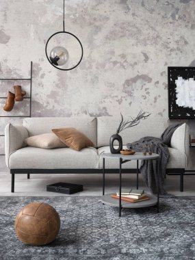 Gri desenli kanepesi, siyah sehpası, siyah merdiveni, gösterişli lambası, halısı, ahşap süsü ve zarif aksesuarları olan modern dairenin çatı katı tarzı. Beton grunge duvar. Şablon.