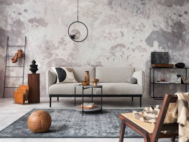 Gri dizayn kanepesi, koltuğu, merdiveni, siyah sehpası, siyah merdiveni, gösterişli lambası, halısı, dekorasyonu ve zarif aksesuarları olan modern dairenin çatı katı tarzı. Beton grunge duvar. Şablon.