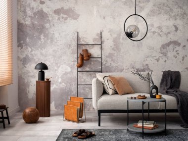 Gri dizayn kanepesi, merdiveni, siyah sehpası, siyah merdiveni, ince lambası, halısı, dekorasyonu ve zarif aksesuarları olan modern dairenin çatı katı tarzı. Beton grunge duvar. Şablon.