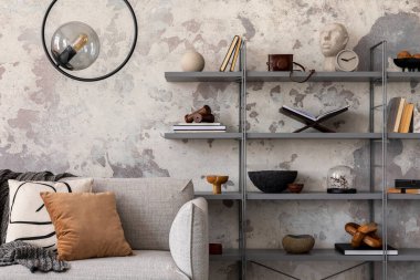 Ekoseli gri kanepeli, kitaplı ve kişisel aksesuarlı Indiustral tarzı modern oturma odası. Gri grunge beton duvar. Ev dekoru. Şablon.