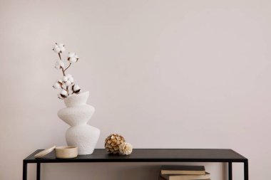 Kopya uzayı ile minimalist iç mekan kompozisyonu. Kurumuş çiçekli beyaz vazo ve şık aksesuarlar. Bej duvar. Ev dekoru. Şablon. 