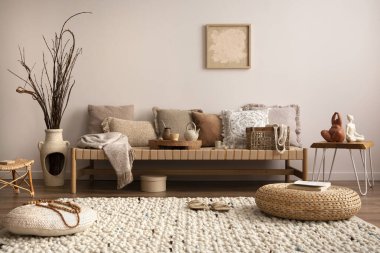 Meditasyon odasının iç kısmının ılık ve rahat kompozisyonu poster çerçevesi, bej halı, renkli yastık, kahve masası ve kişisel aksesuarlarla. Ev dekoru. Şablon. 