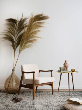 Estetik ve minimalist oturma odasının iç tasarımı, Boucle koltuğu, ahşap sehpa, gösterişli lamba, vazodaki güzel yapraklar, dekorasyon ve kişisel aksesuarlar. Uzayı kopyala Ev dekoru.