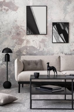 Yapay poster çerçevesi, şık gri kanepe, yeşil yastık, sade kahve masası, saksı ve kişisel aksesuarları olan beton oturma odasının yaratıcı kompozisyonu. Ev dekoru. Şablon.