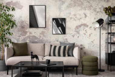Beton oturma odasının iç tasarımı poster çerçevesi, şık gri kanepe, yastıklar, siyah sehpa, kurumuş çiçekler, fincanlar, bitkiler ve kişisel aksesuarlarla dolu vazo. Ev dekoru. Şablon.