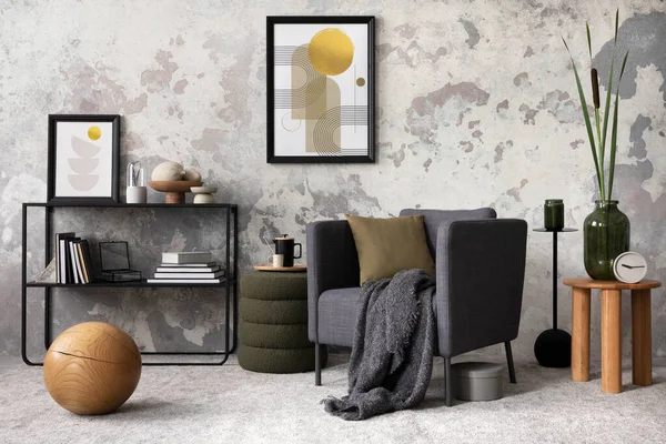 Interior design of loft industrial apartment with gray armchair with mock up poster frame, plaid and pillow, carpet, coffee table and personal accessories. Gray concrete wall. Template.