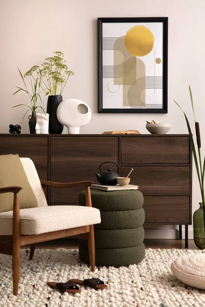 Simple composition of living room interior with mock up poster frame, beige armchair with pillow, carpet, green pouf and wooden commode with personal accessories. Home decor. Template.