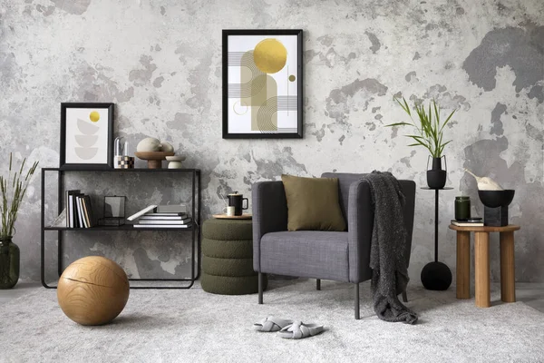 Interior design of loft industrial apartment with gray armchair with mock up poster frame, plaid and pillow, carpet, coffee table and personal accessories. Gray concrete wall. Template.