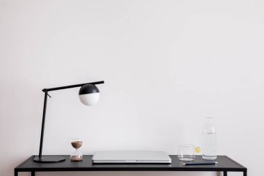 Ofisin minimalist kompozisyonu fotokopi alanı, siyah masa, dizüstü bilgisayar, masa lambası ve kişisel aksesuarlar. Ofis alanı. Ev dekoru. Şablon.