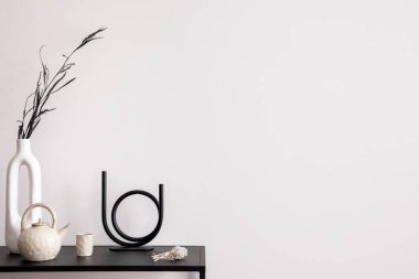 Oturma odasının estetik kısmı fotokopi alanı, beyaz duvar, siyah masa, şamdan, kurutulmuş çiçekler, sürahi ve zarif kişisel aksesuarlarla dolu vazo. Şık bir ev dekoru. Şablon. 