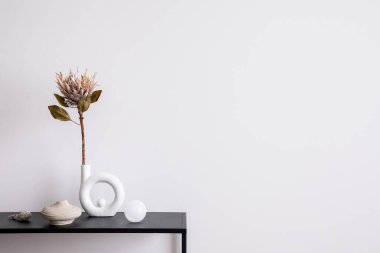 Oturma odasının estetik bölümü, fotokopi alanı, beyaz duvar, siyah masa, kurutulmuş çiçekli vazo, cam top, şamdan ve zarif kişisel aksesuarlar. Şık bir ev dekoru. Şablon.