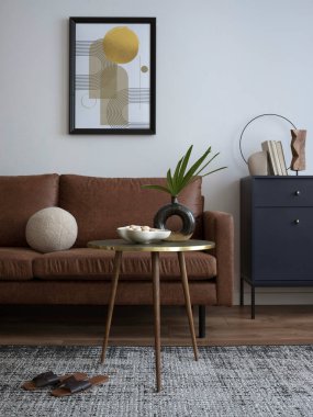 Uyumlu oturma odasının iç tasarımı kahverengi kanepe, mavi tuvalet, sehpa, poster çerçevesi, dekorasyon, halı ve kişisel aksesuarlar. Şık bir ev dekoru. Şablon. 