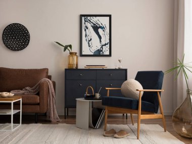 Poster çerçevesi, mavi koltuk, donanma tuvaleti, kahverengi kanepe, halı, dekorasyon, sehpa ve kişisel aksesuarlar. Şık bir ev dekoru. Şablon.