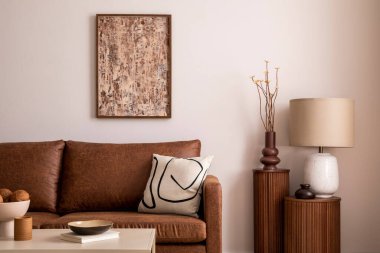 Kahverengi kanepe, lamba, poster çerçevesi, dekorasyon, bitki ve ahşap standı olan sıcak ve rahat bir oturma odası. Sıcak ev dekorasyonu. Şablon. 