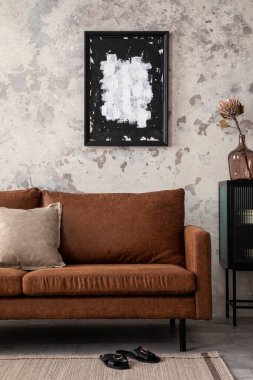 Kahverengi kanepeli modern oturma odası kompozisyonu, poster çerçevesi, siyah tuvalet, kurumuş çiçekli cam vazo, bej yastık ve kişisel aksesuarlar. Ev dekoru. Şablon.