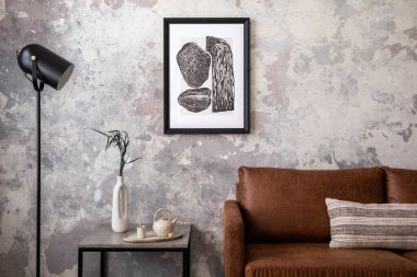 Çatı katı tarzı, poster çerçevesi, kare sehpa, yastık, kurutulmuş çiçekli vazo, şık kahverengi kanepe ve kişisel aksesuarları olan modern bir daire. Ev dekoru. Şablon. 