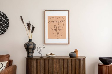 Interior design of living room interior with mock up poster frame, wooden commode, bowl on stand, vase with dried flowers, candle, brown sofa and elegant personal accessories. Home decor. Template. 