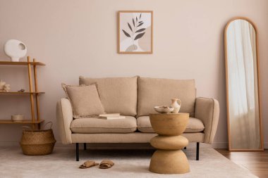 Creative composition of living room interior with mock up poster frame, elegant beige sofa, wooden round coffee table, bright carpet, basket, mirror and personal accessories. Home decor. Template. 