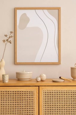 Minimalist composition of living room interior with mock up poster frame, rattan commode, beige wall, vase with dried flowers and personal accessories. Home decor. Template. 