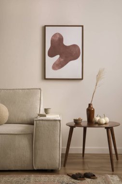 Creative composition of living room interior with mock up poster frame, modern beige sofa, oval wooden coffee table,  round pillow, glass case, craetive bowl with dried fruit, sculpture and personal accessories. Home decor. Template. 