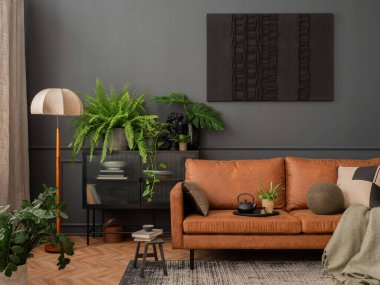 Interior design of living room interior with mock up poster frame, brown sofa, plants,  glass sideboard, stool, wooden floor, lamp and personal accessories. Home decor. Template. 