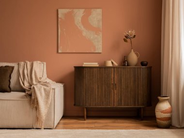 Creative composition of living room interior with mock up poster frame, wooden sideboard, modular beige sofa, brown pouf, plaid, pillows, rug, pink wall and personal accessories. Home decor. Template.