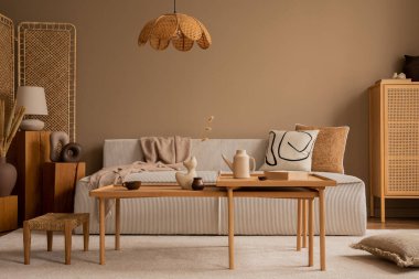 Modüler kanepe, ahşap sehpa, rattan büfe, bej halı, yastıklar ve kişisel aksesuarlarla oturma odasının yaratıcı kompozisyonu. Ev dekoru. Şablon. 