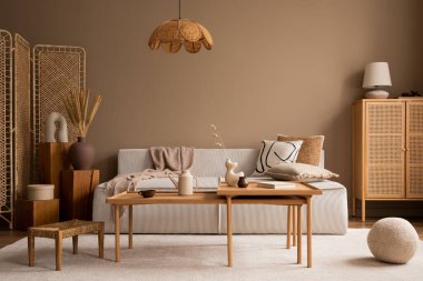 Modüler kanepe, ahşap sehpa, ahşap büfe, yeşil yastık, lamba, kahverengi pouf, bej halı, bitkiler ve kişisel aksesuarlar ile oturma odasının iç tasarımı. Ev dekoru. Şablon. 