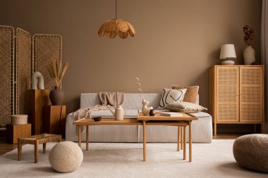 Modüler kanepe, ahşap sehpa, rattan büfe, bej halı, yastıklar ve kişisel aksesuarlarla oturma odasının yaratıcı kompozisyonu. Ev dekoru. Şablon. 