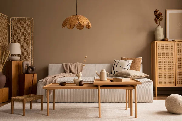 Creative composition of living room interior with modular sofa, wooden coffee table, rattan sideboard, beige rug, pillows and personal accessories. Home decor. Template.