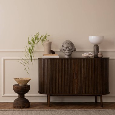 Fotokopi alanı, ahşap büfe, gri heykel, yeşil yapraklı vazo, ahşap tezgah, kase, mermer lamba ve kişisel aksesuarlarla oturma odasının zarif kompozisyonu. Ev dekoru. Şablon. 