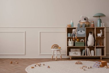 Çocuk odasının iç tasarımı fotokopi alanı, ahşap büfe, yuvarlak halı, bej duvar, peluş oyuncaklar, beyaz tabure, ahşap bloklayıcı ve kişisel aksesuarlar. Ev dekoru. Şablon. 