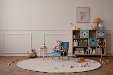 Çocuk odasının içinde fotokopi alanı, poster çerçevesi, mavi koltuk, ahşap büfe, bej halı peluş oyuncaklar, ahşap bloklayıcılar ve kişisel aksesuarlar olan minimalist kompozisyonu. Ev dekoru. Şablon