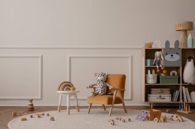 Fotokopi alanı, turuncu koltuk, ahşap büfe, yuvarlak tabure, bej halı pelüşlü oyuncaklar, ahşap bloklayıcılar ve kişisel aksesuarlarla çocuk odasının minimalist kompozisyonu. Ev dekoru. Şablon.