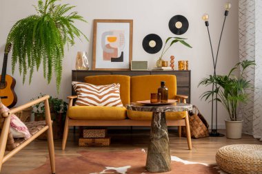 Poster çerçevesi, sarı kanepe, ahşap sehpa, gitar, bitkiler, klozet, dekorasyon ve kişisel aksesuarlarla dolu eski ve rahat bir yemek odası. Şık bir ev dekoru. Şablon.