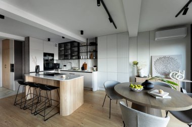 Mutfak odasının modern kompozisyonu mutfak adası, siyah fahişeler, gri masa, çiçekler, mobilyalar, büyük pencere ve zarif kişisel aksesuarlar. Şık bir ev dekoru. Şablon