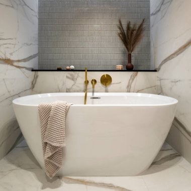 Altın bantlı, mavi ve pembe fayanslı zarif banyonun iç tasarımı, klasik beyaz banyo, klozet oturağı, ipek, kurumuş çiçekli kahverengi vazo. Ev dekoru. Şablon. 