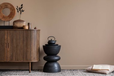 Oturma odasının estetik kompozisyonu fotokopi alanı, ahşap büfe, şık heykel, kurumuş çiçekli vazo, siyah durak, bej yastık ve kişisel aksesuarlar. Ev dekoru. Şablon.