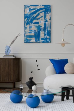 Oturma odasının modern kompozisyonu poster çerçevesi, ahşap büfe, cam sehpa, şık kanepe, mavi yastık ve kişisel aksesuarlar. Ev dekoru. Şablon.