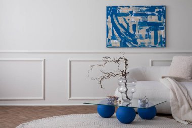 Oturma odasının modern kompozisyonu fotokopi alanı, poster çerçevesi, şık bir kanepe, cam sehpa, bej yastık, fındıklı kase, yuvarlak halı ve kişisel aksesuarlar. Ev dekorasyonu Şablonu