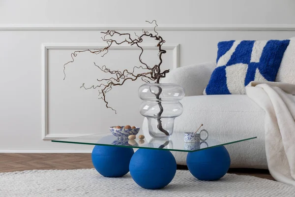 客厅内的现代构图 有时尚的白色沙发 蓝色玻璃咖啡桌 蓝色枕头 坚果碗 圆形地毯和个人配饰 家居装饰模板 — 图库照片