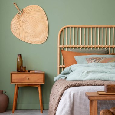 Bambu yataklı, modern çarşaflı, komodinli ve şık aksesuarlı zarif yatak odası iç tasarımı. Okaliptüs duvarı. Şablon. Boşluğu kopyala.