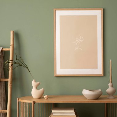 Model poster çerçeveleri, ahşap çekmeceler, bej vazo ve yaratıcı ev aksesuarları olan şık bir oturma odası tasarımı. Bilge yeşil duvar. Şablon. 
